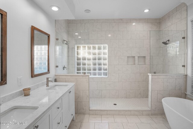 bathroom with vanity, ornamental molding, and tiled shower