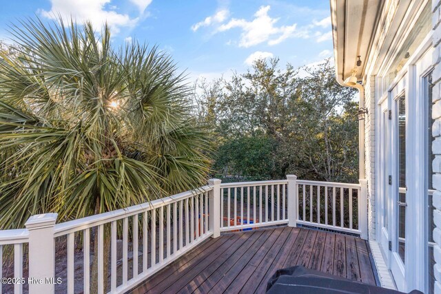 wooden deck with grilling area and a sunroom