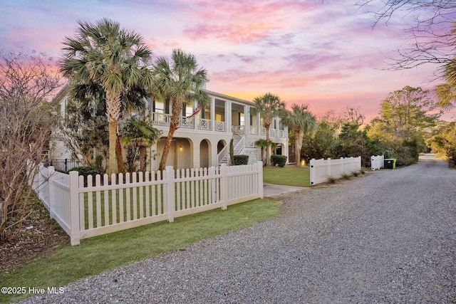 view of front facade featuring a lawn, a porch, and a balcony