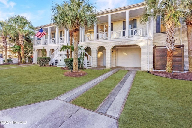 view of front facade with a porch, a front yard, and a garage