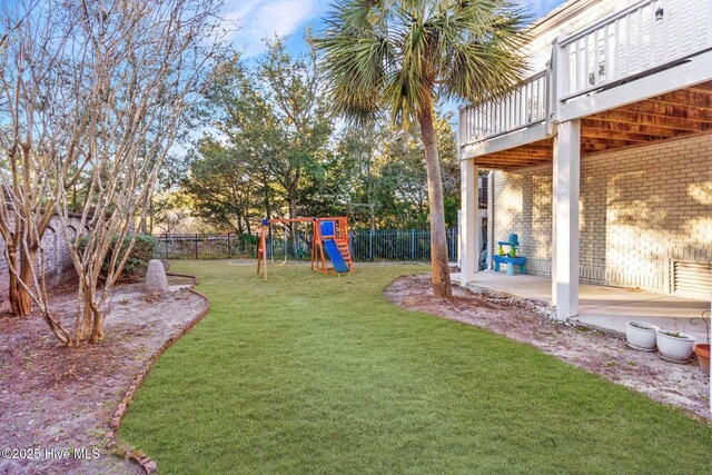 rear view of house with a playground, central AC unit, a yard, and a wooden deck