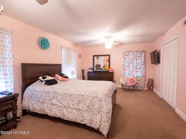 carpeted bedroom featuring a closet, a textured ceiling, and ceiling fan