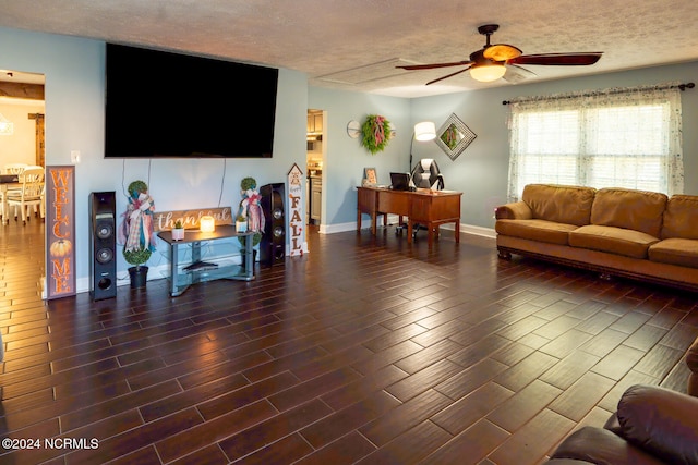 living room with a textured ceiling, dark hardwood / wood-style floors, and ceiling fan