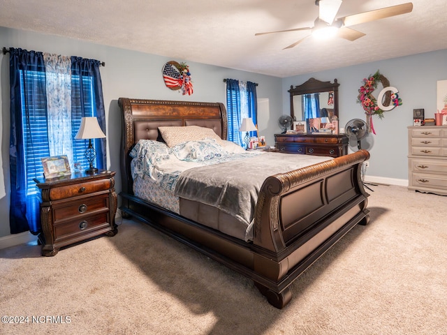 carpeted bedroom featuring a textured ceiling and ceiling fan