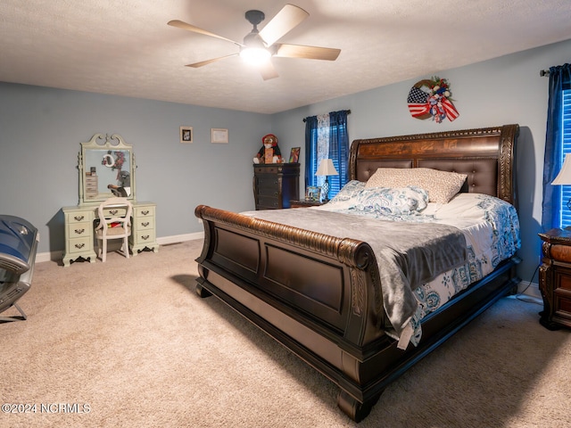 carpeted bedroom featuring a textured ceiling and ceiling fan