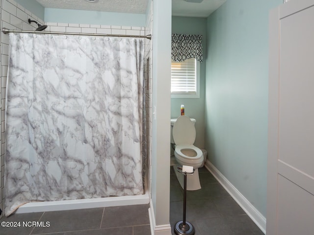 bathroom with curtained shower, a textured ceiling, toilet, and tile patterned flooring