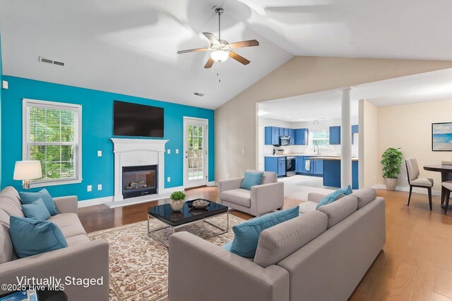 8525 Primm Forest Dr, Leland, NC 28451 - unfurnished living room featuring a wealth of natural light, visible vents, ceiling fan, a glass covered fireplace, and lofted ceiling