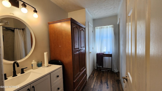 bathroom featuring vanity, hardwood / wood-style floors, a textured ceiling, and a shower with shower curtain