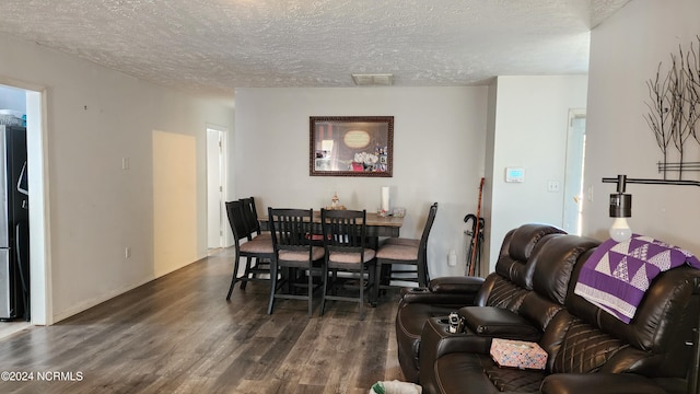 dining room featuring dark hardwood / wood-style floors and a textured ceiling