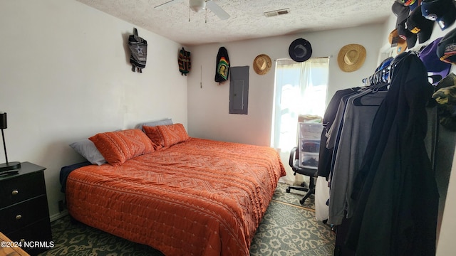 bedroom featuring electric panel, a textured ceiling, and ceiling fan