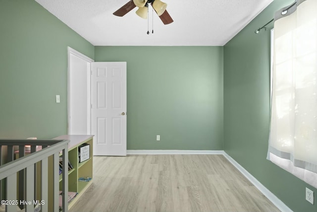 empty room featuring a textured ceiling, ceiling fan, and light hardwood / wood-style floors