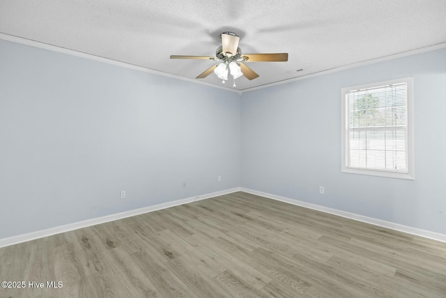 empty room with ceiling fan, a textured ceiling, ornamental molding, and light hardwood / wood-style floors