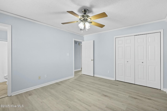 unfurnished bedroom with light hardwood / wood-style floors, ceiling fan, connected bathroom, a textured ceiling, and crown molding