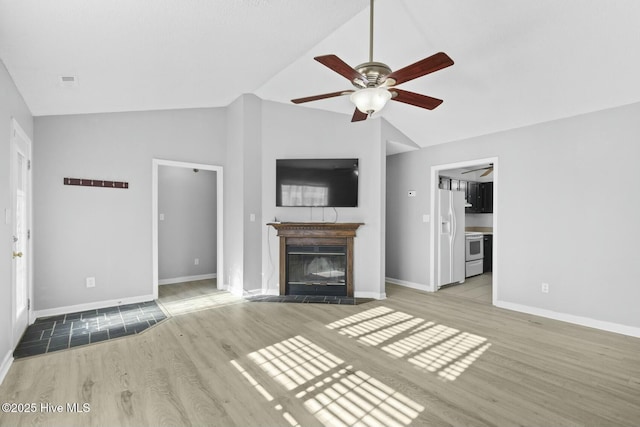 unfurnished living room featuring light wood-type flooring, vaulted ceiling, and ceiling fan