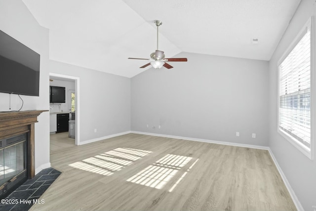 unfurnished living room with vaulted ceiling, ceiling fan, and light hardwood / wood-style floors