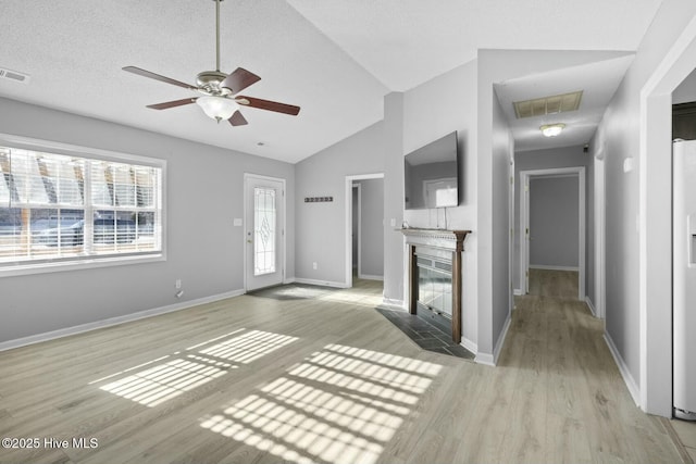 unfurnished living room with ceiling fan, light hardwood / wood-style floors, and vaulted ceiling