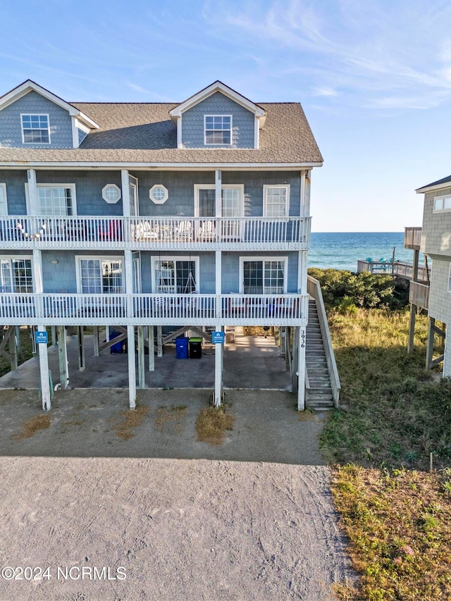 view of front of property featuring a water view, a carport, and a balcony