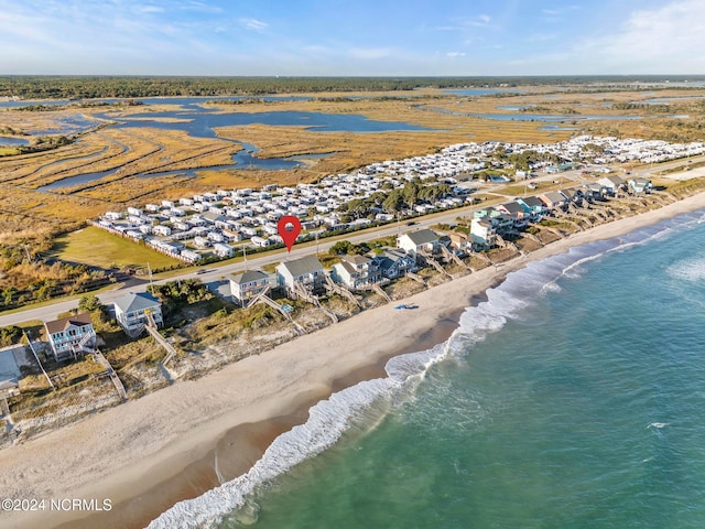 bird's eye view featuring a water view and a beach view