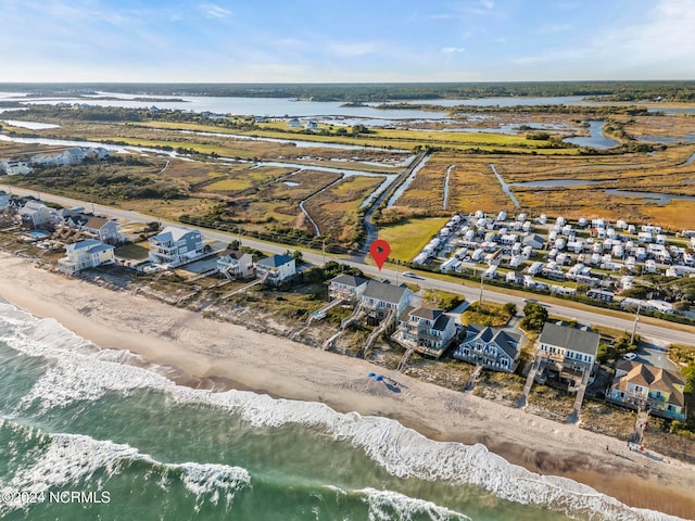 bird's eye view featuring a water view and a beach view