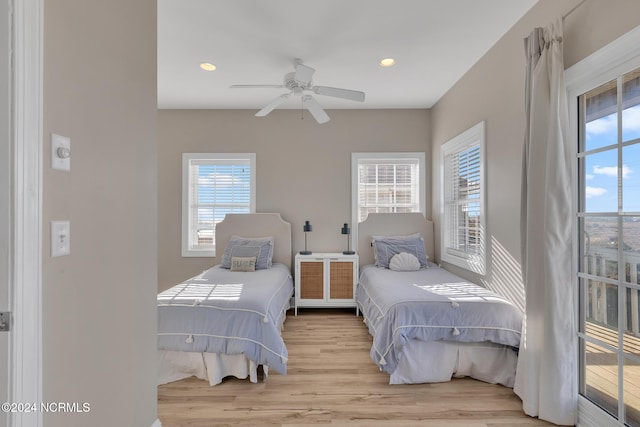 bedroom with multiple windows, radiator, light wood-type flooring, and ceiling fan