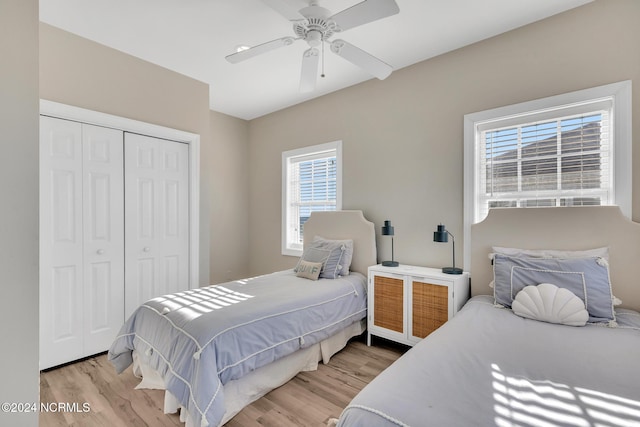 bedroom with light hardwood / wood-style floors, multiple windows, and a closet