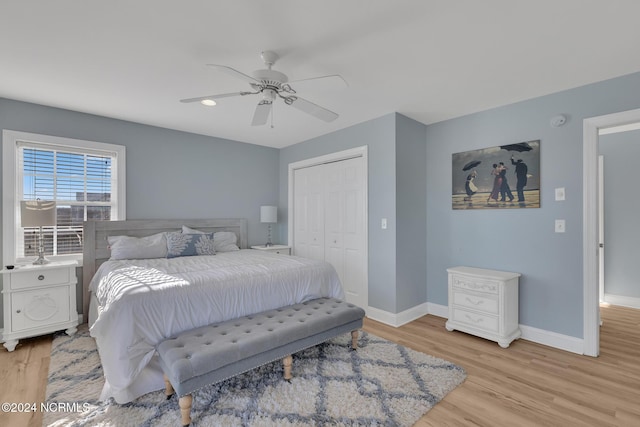 bedroom featuring light hardwood / wood-style flooring, a closet, and ceiling fan