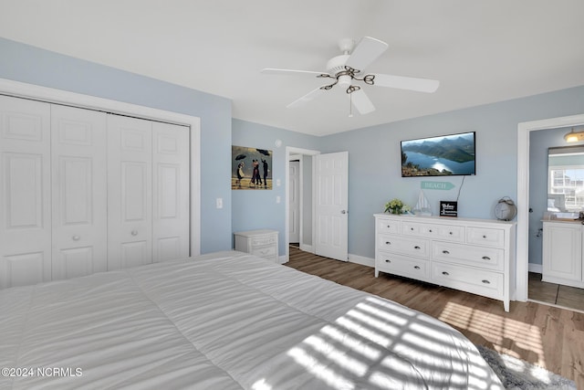 bedroom featuring connected bathroom, dark wood-type flooring, a closet, and ceiling fan