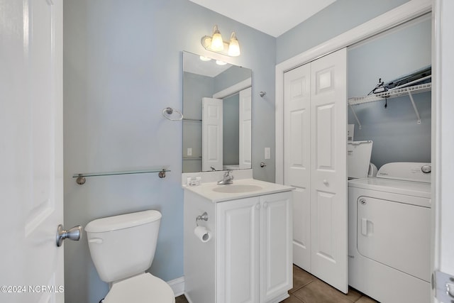 bathroom featuring toilet, washer / clothes dryer, vanity, and tile patterned flooring