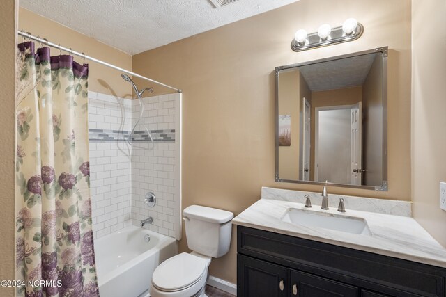 full bathroom featuring vanity, toilet, shower / bath combo with shower curtain, and a textured ceiling