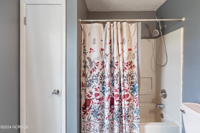 bathroom featuring shower / bath combo with shower curtain, a textured ceiling, and toilet