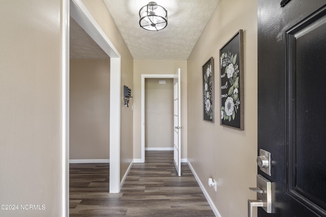 hallway featuring a textured ceiling and dark hardwood / wood-style floors