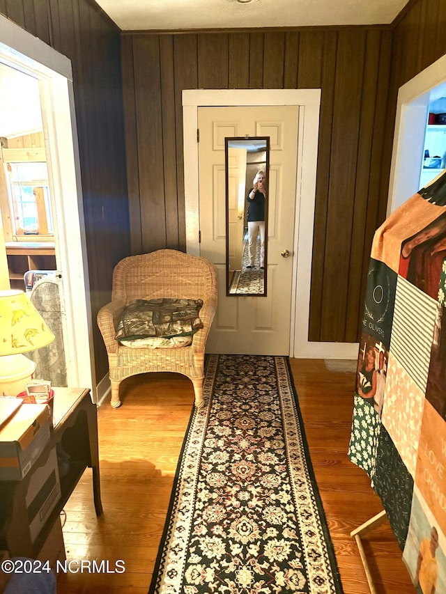 corridor with wood-type flooring and wooden walls