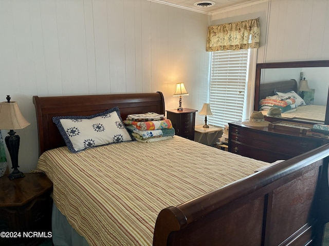 bedroom featuring crown molding and wood walls