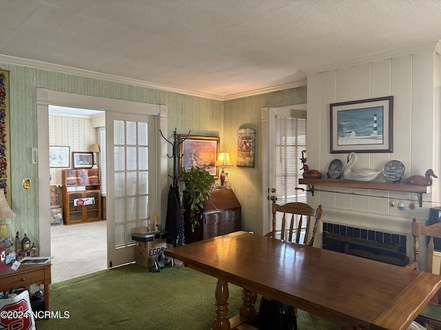 dining area with a textured ceiling, crown molding, and carpet flooring