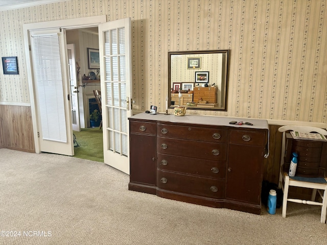 bedroom with french doors, crown molding, and light carpet