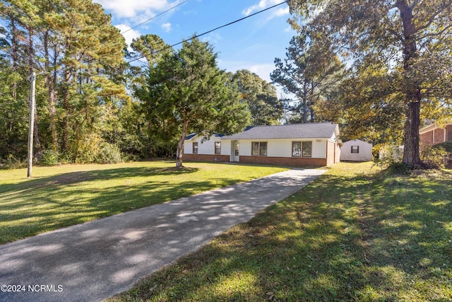 view of front of property featuring a storage unit and a front yard