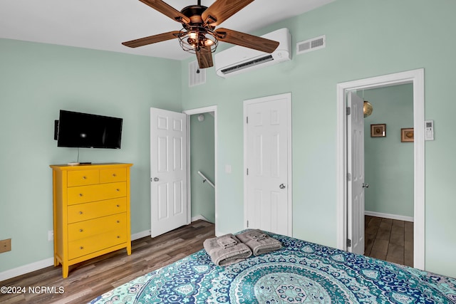 bedroom featuring dark wood-type flooring, ceiling fan, and an AC wall unit