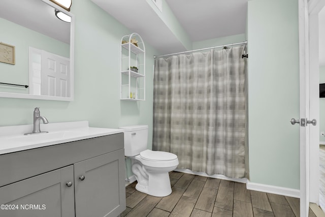 1928 New River Inlet Rd Unit 207, North Topsail Beach, NC 28460 - bathroom featuring wood tiled floors, vanity, toilet, and curtained shower