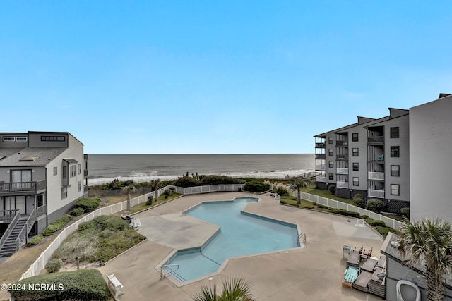 view of swimming pool with a patio area and a water view