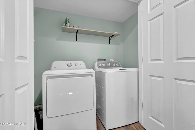 washroom featuring hardwood / wood-style floors and separate washer and dryer