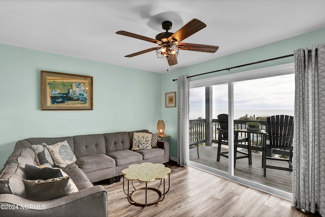 living room with light hardwood / wood-style flooring, a water view, and ceiling fan