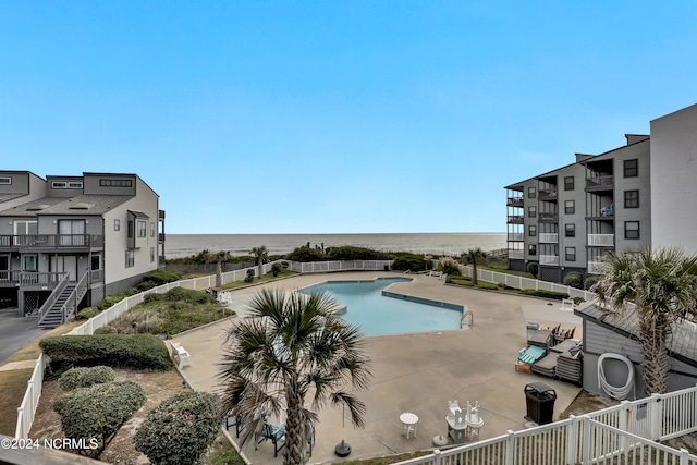 view of pool featuring a water view and a patio