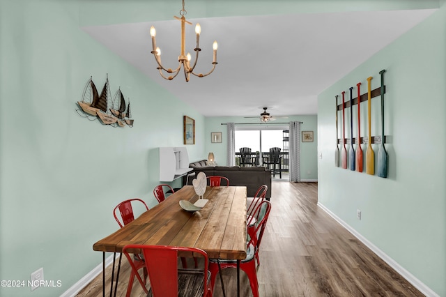 dining space featuring wood-type flooring and ceiling fan with notable chandelier