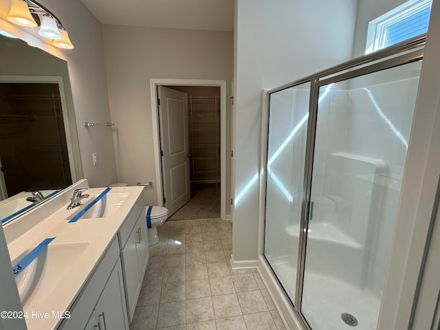 bathroom with vanity, toilet, tile patterned floors, and a shower with shower door