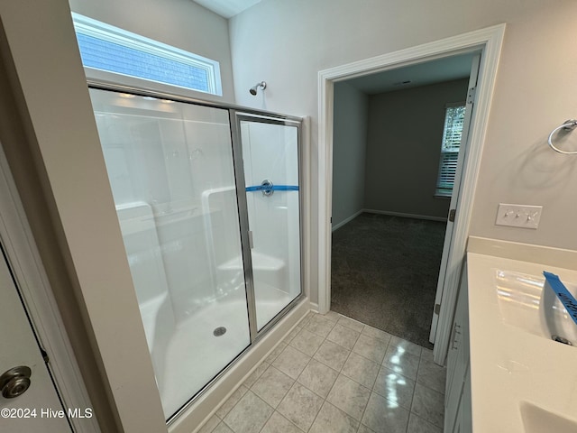 bathroom featuring vanity, a shower with shower door, and tile patterned flooring