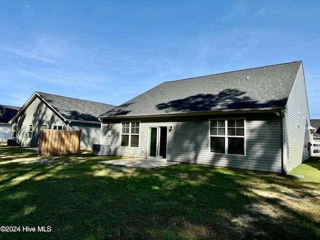 back of property with cooling unit, a patio area, and a lawn