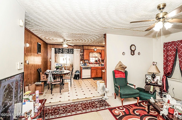 interior space with wood walls, a textured ceiling, and ceiling fan