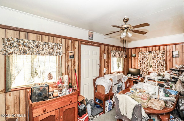 carpeted bedroom featuring multiple windows, wood walls, and ceiling fan