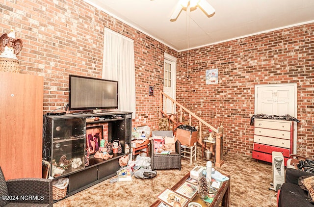 living room with brick wall, ornamental molding, carpet flooring, and ceiling fan