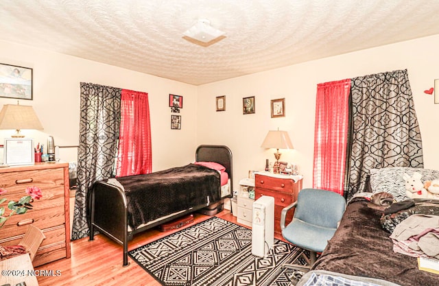 bedroom with hardwood / wood-style floors and a textured ceiling